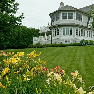 Manicured lawn and daylilies surrounding a coastal home